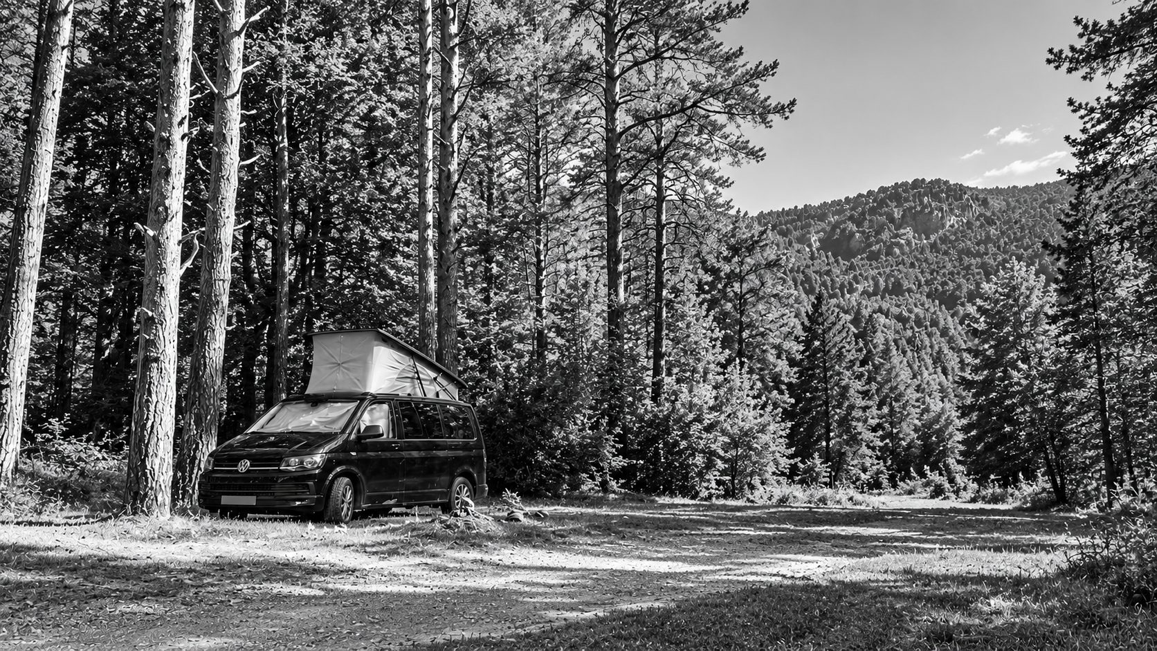 La furgo en blanc i negre, sola en un clar de bosc de muntanya